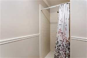 Bathroom featuring walk in shower and ornamental molding