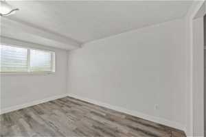 Empty room with LVP flooring and a textured ceiling