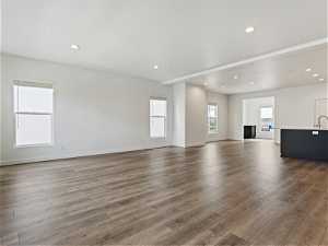 Unfurnished living room featuring hardwood / wood-style flooring and sink