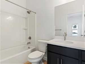Full bathroom with  shower combination, large vanity, and toilet