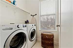 Laundry room with independent washer and dryer, light tile floors, and plenty of natural light