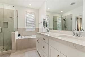 Bathroom with dual bowl vanity, separate shower and tub, and tile floors