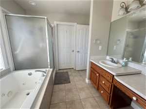 Bathroom featuring tile flooring, a textured ceiling, vanity, and walk in shower