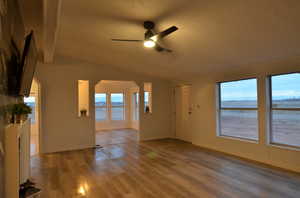 Living room with vaulted ceiling, LVP flooring, and ceiling fan