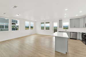 Kitchen with a kitchen island, appliances with stainless steel finishes, light hardwood / wood-style floors, and plenty of natural light