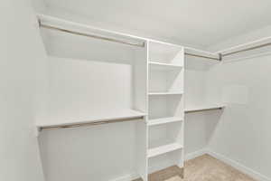 Walk in closet featuring light colored carpet