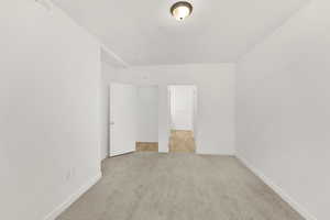 Unfurnished bedroom featuring light colored carpet