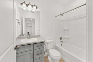 Full bathroom featuring vanity, toilet, tile flooring, and washtub / shower combination