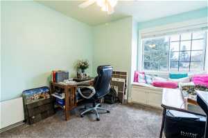 Carpeted office space featuring ceiling fan