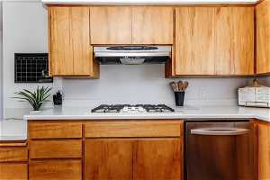 Kitchen with white gas stovetop, extractor fan, and dishwasher