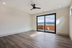 Spare room with plenty of natural light, dark hardwood / wood-style flooring, and ceiling fan