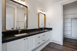 Bathroom with double vanity and hardwood / wood-style floors