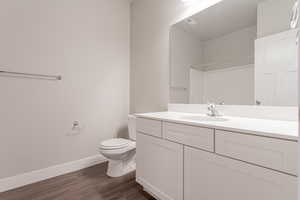 Bathroom with vanity, toilet, and hardwood / wood-style floors