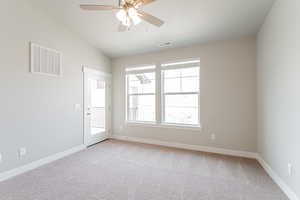 Carpeted empty room featuring ceiling fan, a textured ceiling, and vaulted ceiling