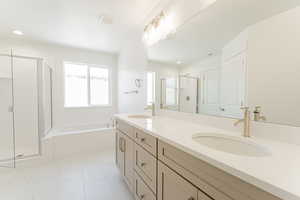 Bathroom with independent shower and bath, tile patterned floors, and dual bowl vanity