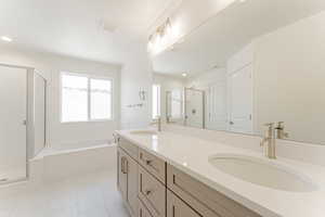 Bathroom featuring tile patterned floors, separate shower and tub, and double vanity