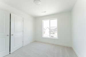 Unfurnished bedroom featuring light colored carpet