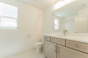 Bathroom with tile patterned floors, vanity, and toilet