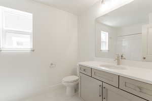 Bathroom with tile patterned floors, toilet, and vanity