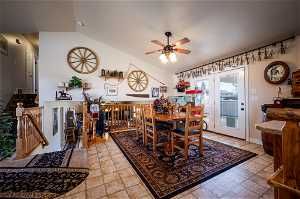Tiled dining room with vaulted ceiling and ceiling fan