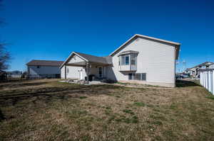 Rear view of house featuring a yard