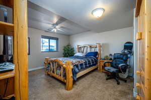 Bedroom with light colored carpet, a textured ceiling, and ceiling fan