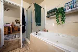 Bathroom featuring tile flooring, ceiling fan, and plus walk in shower