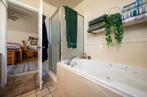 Bathroom featuring tile flooring, ceiling fan, and plus walk in shower