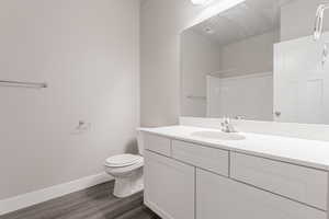 Bathroom featuring wood-type flooring, toilet, and vanity