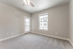 Empty room with light colored carpet, a textured ceiling, and ceiling fan