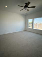 Carpeted empty room with ceiling fan