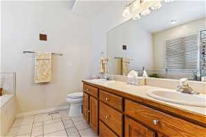 Bathroom with dual bowl vanity, toilet, and tile floors