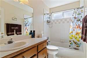Full bathroom featuring tile floors, shower / bath combination with curtain, toilet, and oversized vanity