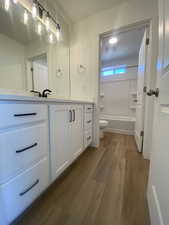 Full bathroom featuring shower / tub combination, vanity, toilet, and hardwood / wood-style floors. Pictures are for reference only of the MAINE floor plan. Actual finishes may vary.