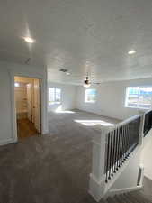 Carpeted empty room with a textured ceiling. Pictures are for reference only of the MAINE floor plan. Actual finishes may vary.