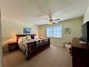 Master Bedroom featuring light carpet, a textured ceiling, and ceiling fan