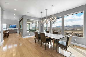 Dining room featuring ceiling fan with notable chandelier, light wood-type flooring, and a mountain view