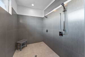 Bathroom featuring tiled shower and tile flooring