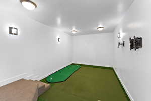 Rec room with golf simulator and carpet flooring