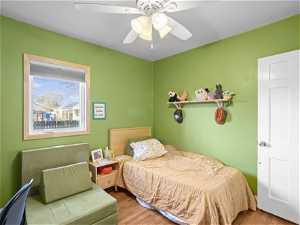 Bedroom with ceiling fan and light hardwood