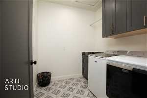 Laundry room with cabinets, light tile floors, and washing machine and dryer