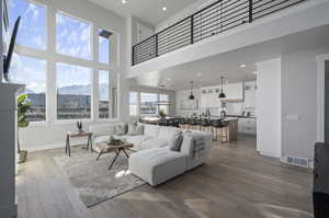 Living room featuring a mountain view, a towering ceiling, and hardwood / wood-style floors