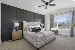 Carpeted bedroom featuring a mountain view, vaulted ceiling, and ceiling fan