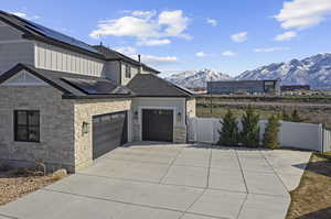 View of home's exterior featuring a mountain view, solar panels, and a garage