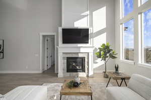 Living room featuring light wood-type flooring and a towering ceiling