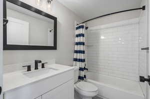 Full bathroom featuring vanity, toilet, and shower / bath combo with shower curtain