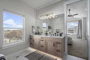 Bathroom featuring double sink, vanity with extensive cabinet space, tile flooring, and ceiling fan