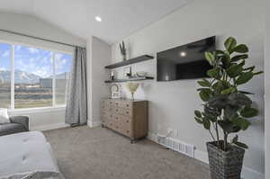 Bedroom featuring lofted ceiling, light colored carpet, and a mountain view