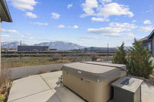 View of patio / terrace with a hot tub and a mountain view