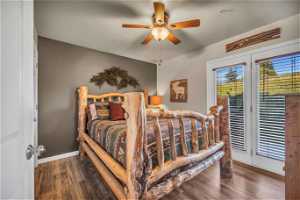 Bedroom featuring french doors, dark wood-type flooring, and ceiling fan